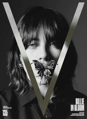 A V Magazine cover, “Billie in Bloom”: a butterfly jewel held at the lips behind a silver V.
