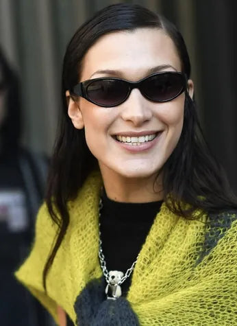 A street portrait in dark glasses, a yellow mohair scarf and a jewelled pendant.