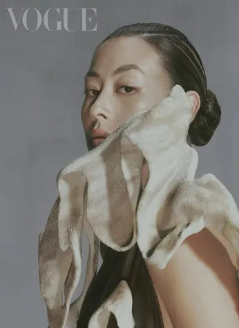 A Vogue cover: a model with a sculpted cream ruffle drawn up to her cheek.