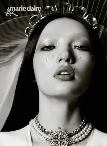 A Marie Claire cover in black and white: a model in a jewelled crown and pearl choker.