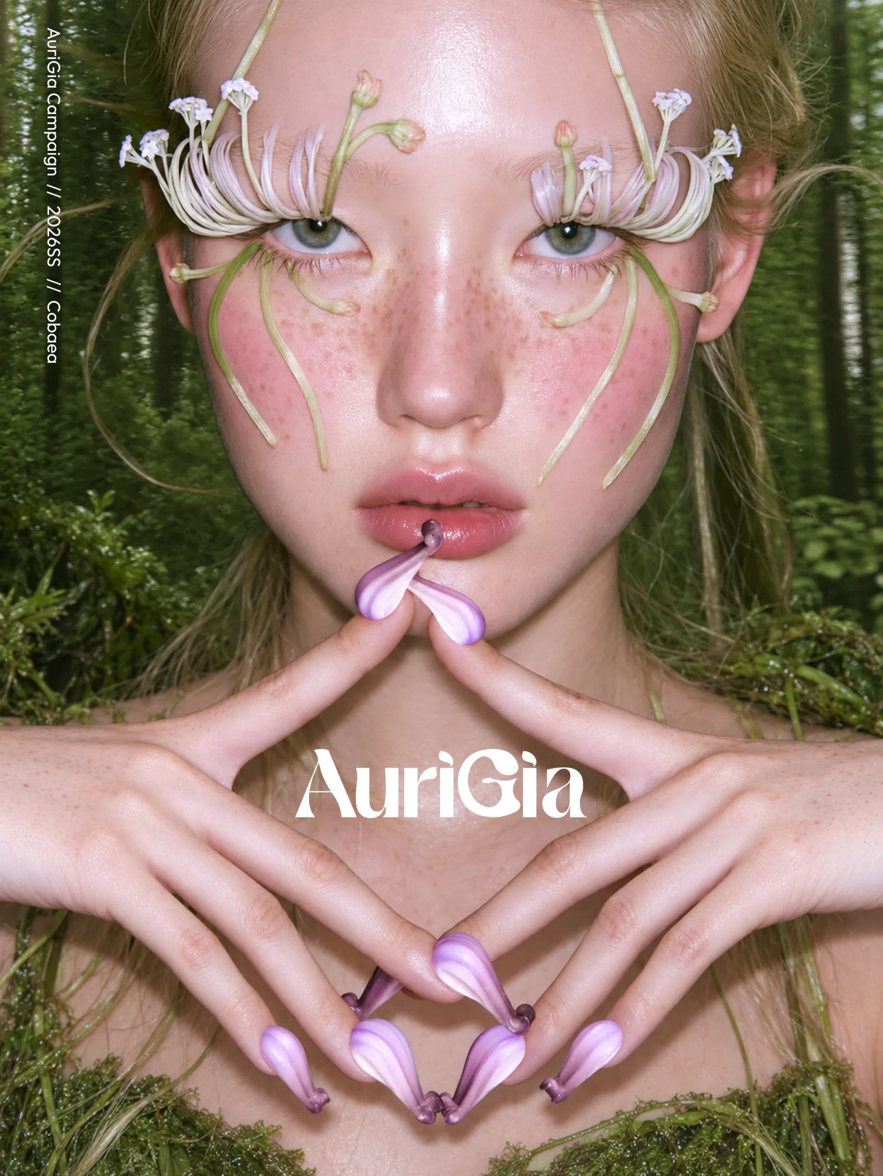 AuriGia Campaign // 2026SS // Cobaea. A model in a mossy forest, flower stems arched above her eyes and Cobaea fingertip rings on every finger. Shop Cobaea.
