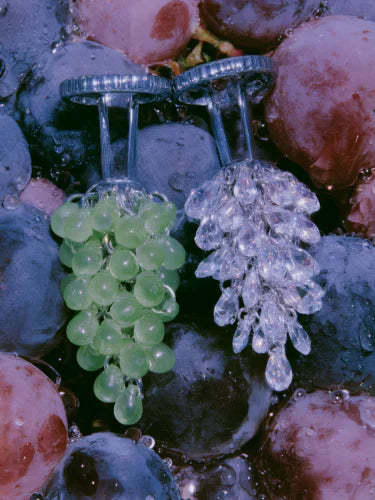 A green and a clear Pistil cluster lying among wet grapes.