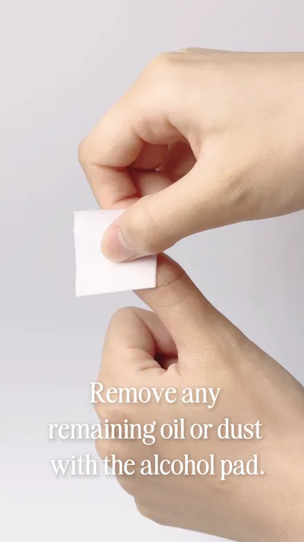 Step 2 of 10. Remove any remaining oil or dust with the alcohol pad — a fingertip being wiped with a folded pad.