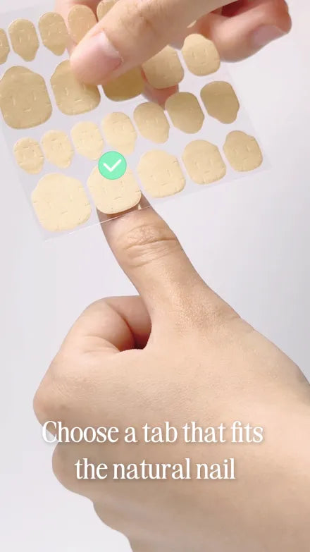 Step 4 of 10. Choose a tab that fits the natural nail — a sheet of adhesive tabs held against a fingertip, one tab ticked.